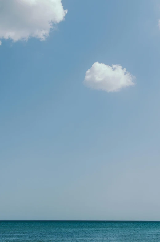 a lone boat in the water and clouds in the sky