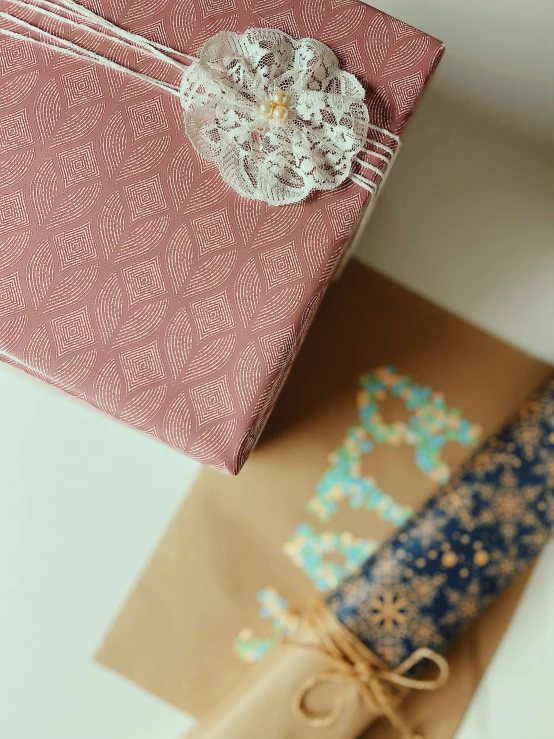 a pink wrapped present box is surrounded by brown wrapping paper