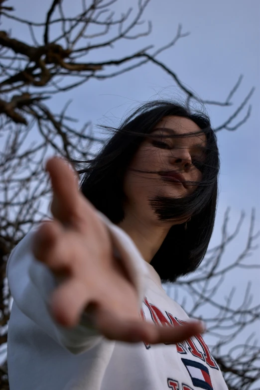 a woman with a painted face and hand making the vulcan sign