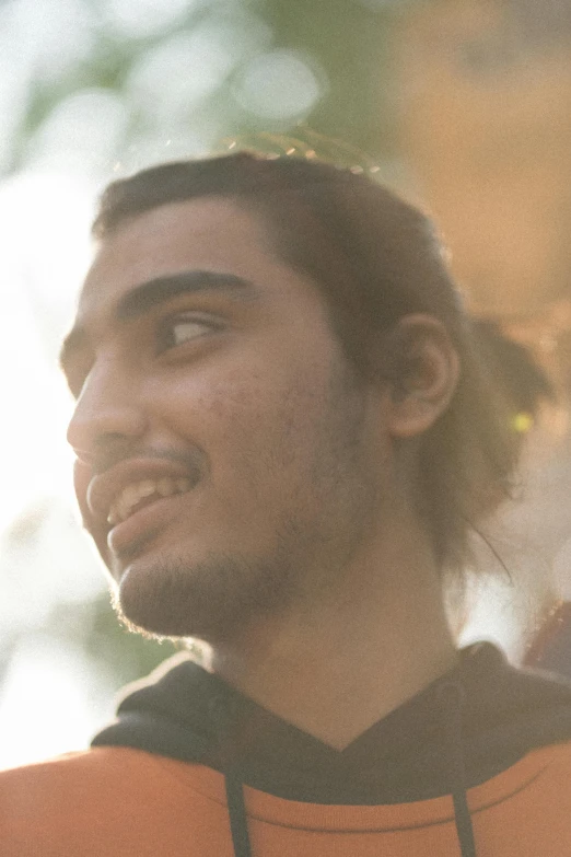 a close up of a person wearing an orange shirt