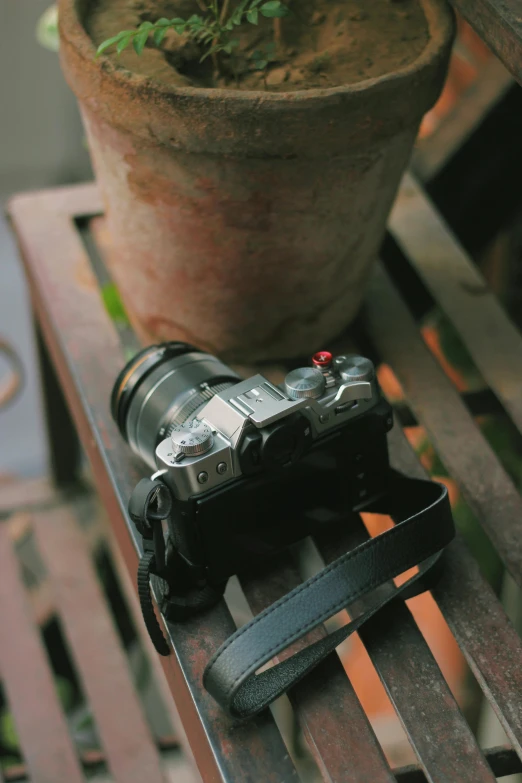 a black camera on top of a wooden bench