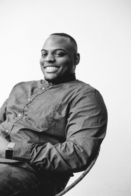 black and white pograph of a smiling african american guy in a chair