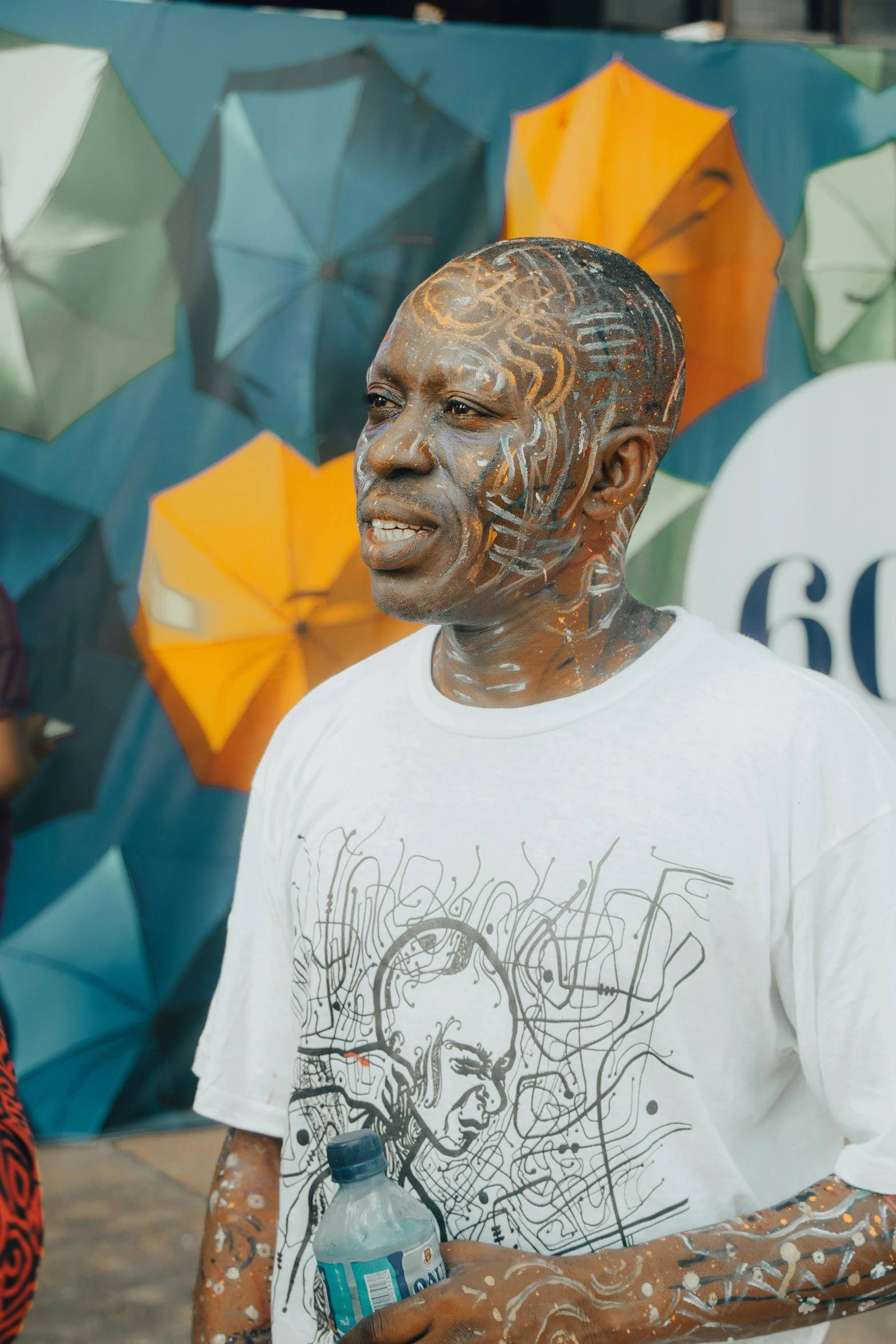 a man with tattoos on his face is standing in front of a wall