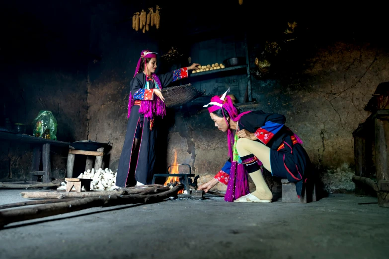 two women in traditional clothing are doing soing