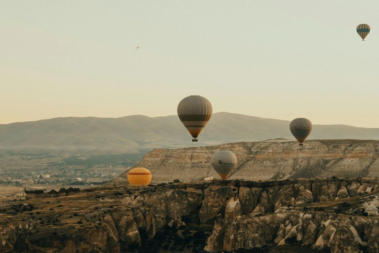 several  air balloons in the sky over a mountain