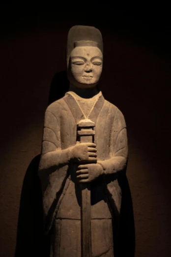 a statue of a person holding a small pole