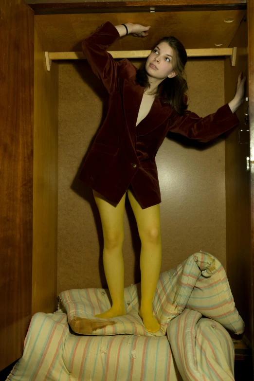 a woman with long legs and yellow stockings on standing on top of a bed