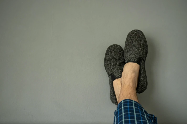 a person standing on one leg wearing a blue plaid shirt