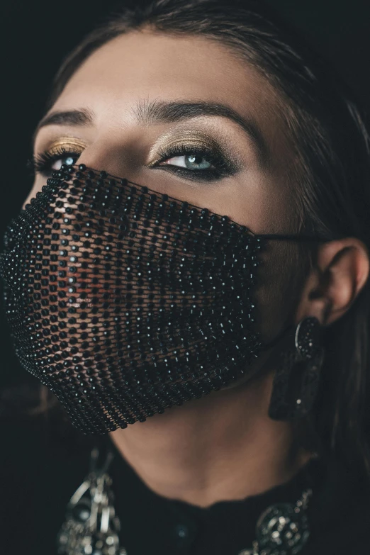 the woman is wearing a mask with her face covered by strings