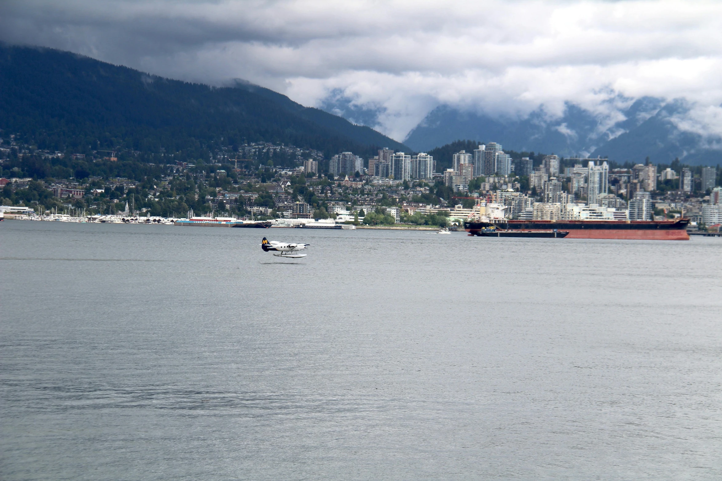 a small boat in the water next to a mountain range