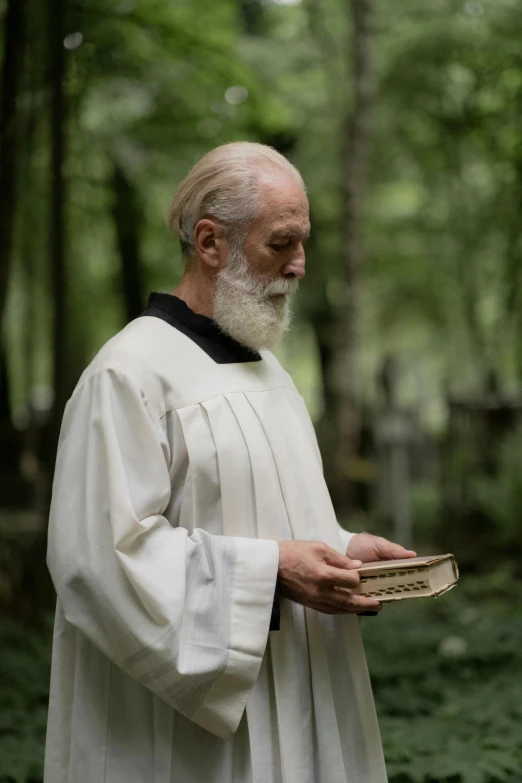 a man in white holding a piece of paper