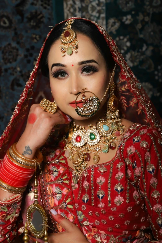 woman dressed in a red and gold outfit posing for a po