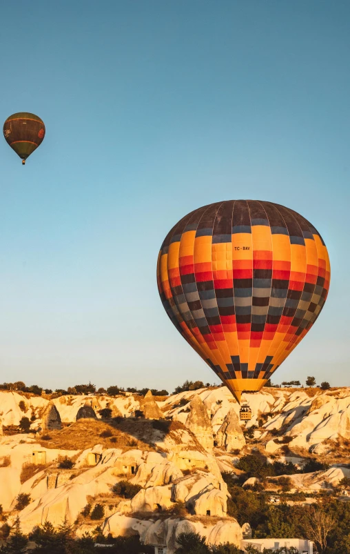 a couple of balloons flying above some rocks