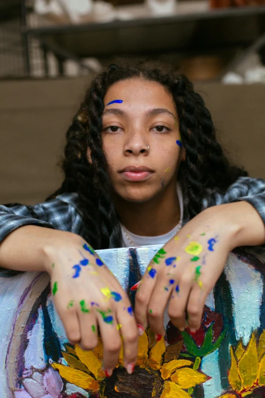 girl with painted nails making peace sign above floral wreath