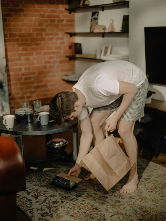 a man putting bags into a paper bag