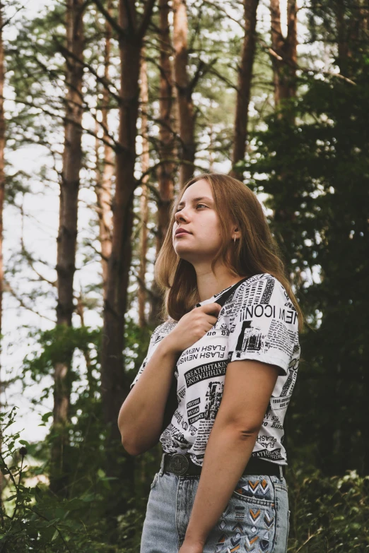 the girl is standing in a forest