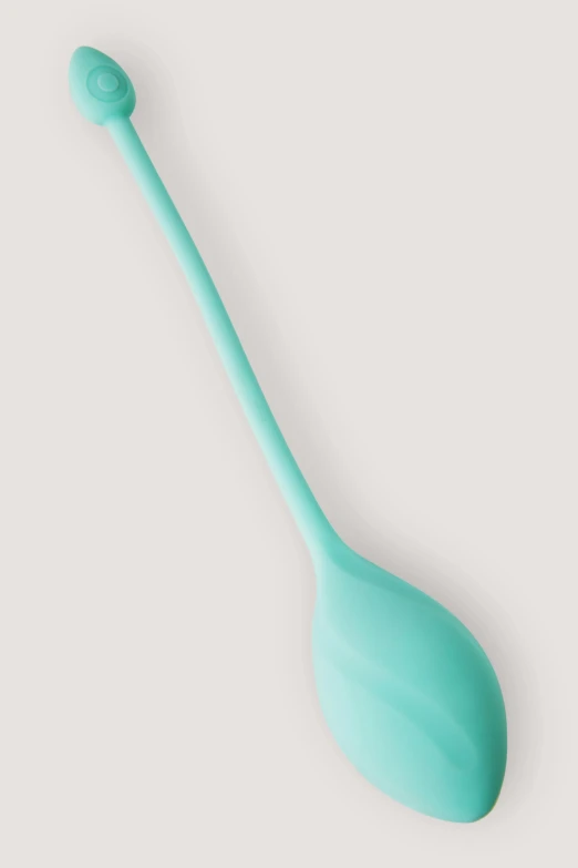 the teal spoon is sitting on a table