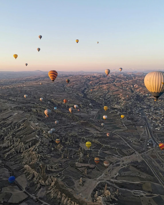 a vast expanse of  air balloons above a town