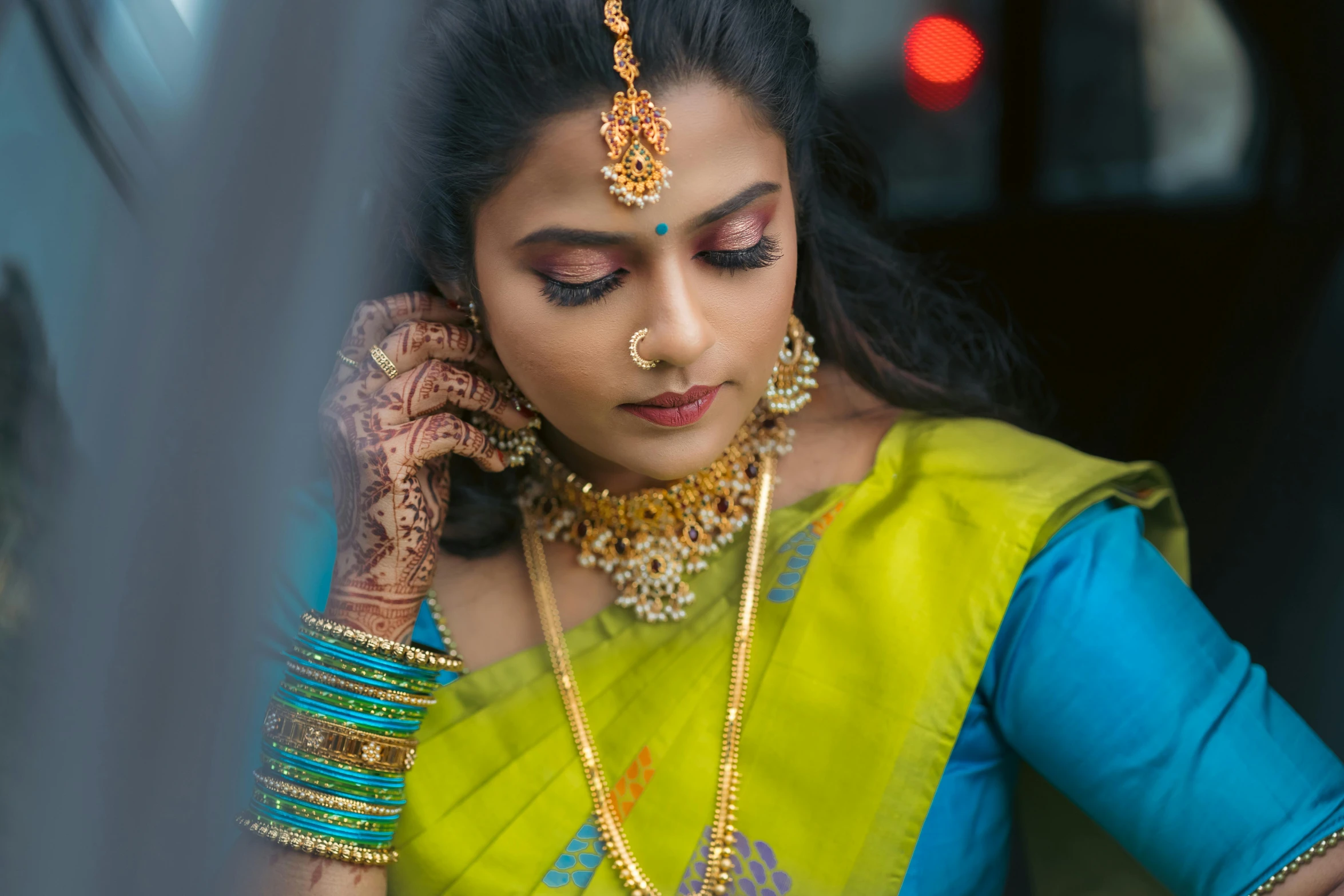 a woman wearing gold jewellery on her neck and hand