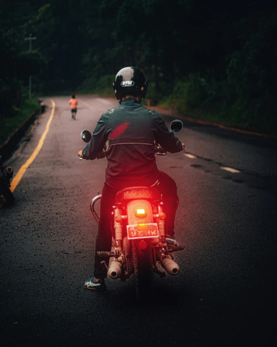 a person on a motorbike at night riding on the road