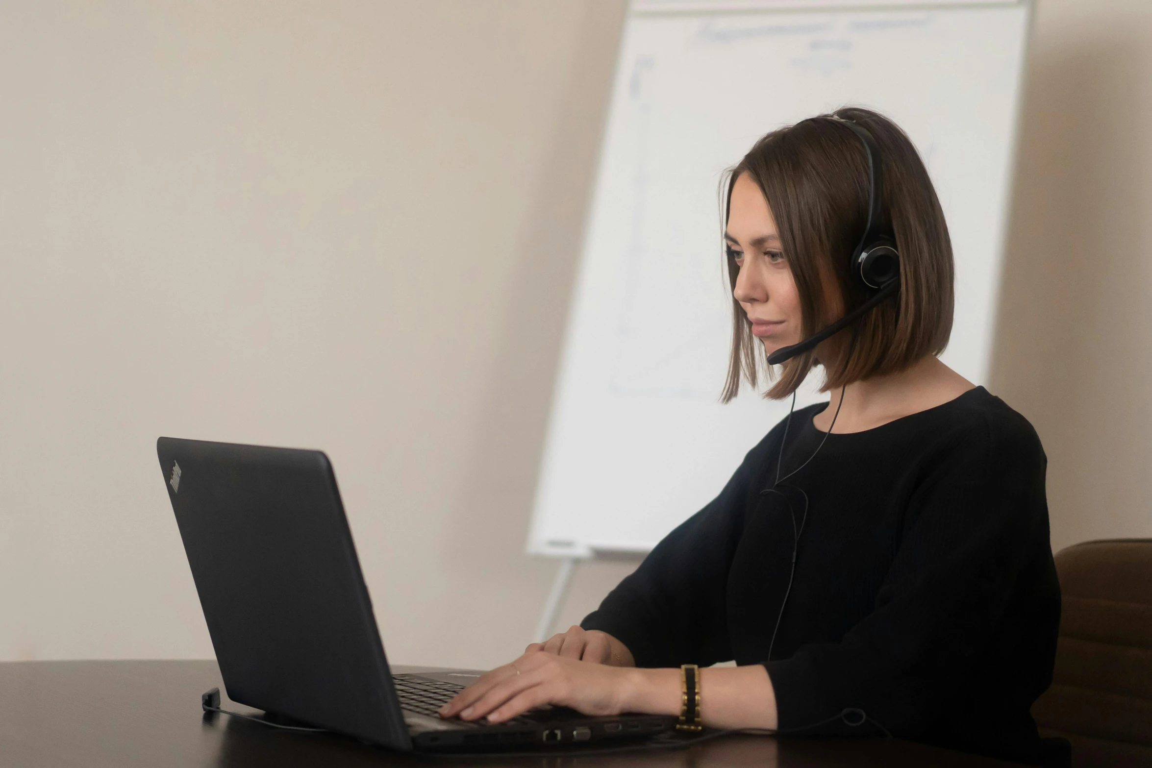 a woman wearing headphones while using her laptop