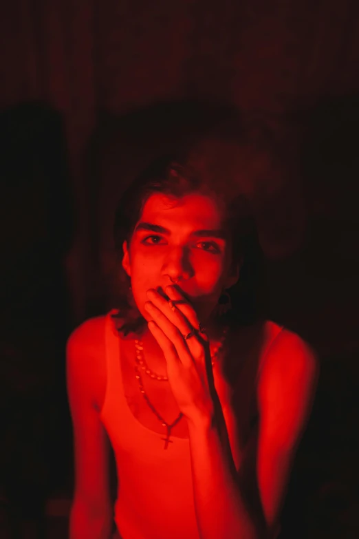 a girl smoking a cigarette in front of red lighting