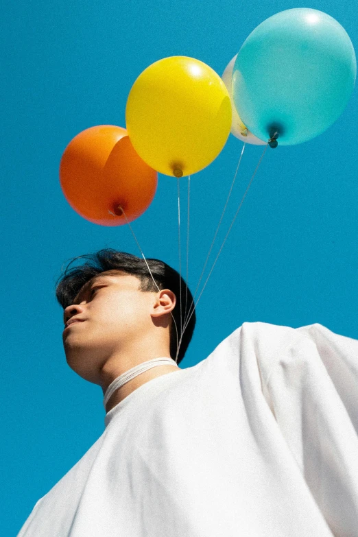 man with bunches of balloons flying in the air