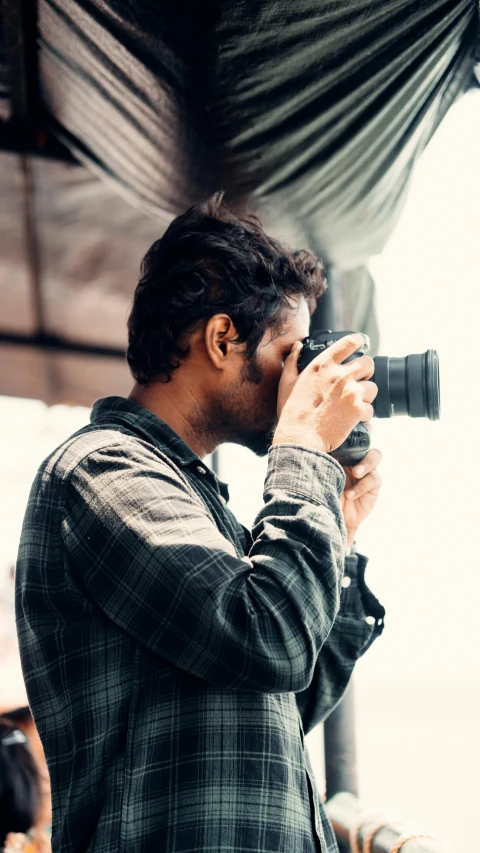 a man is holding a camera and taking pictures