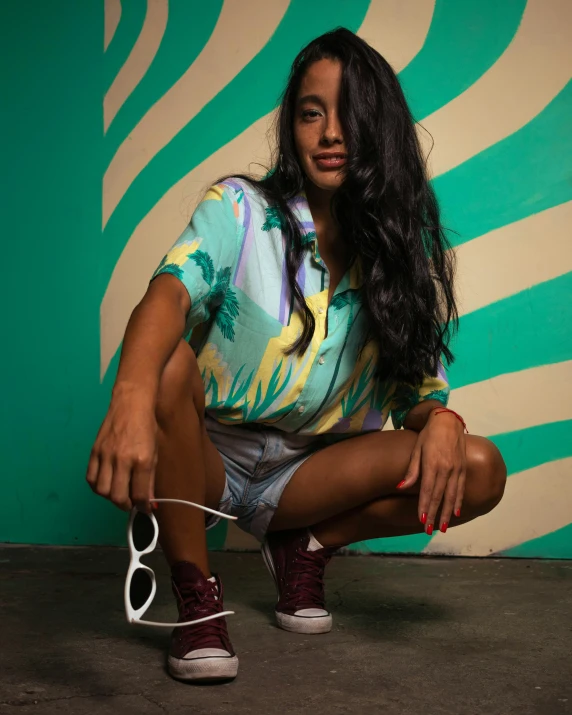 a woman posing in front of a green striped wall