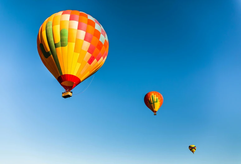 several colorful  air balloons flying over a beach