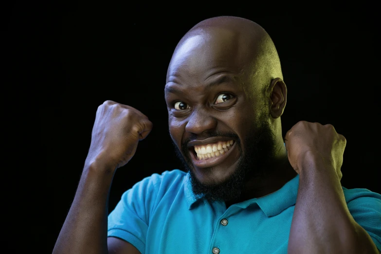 a balding, black man with blue shirt and beard