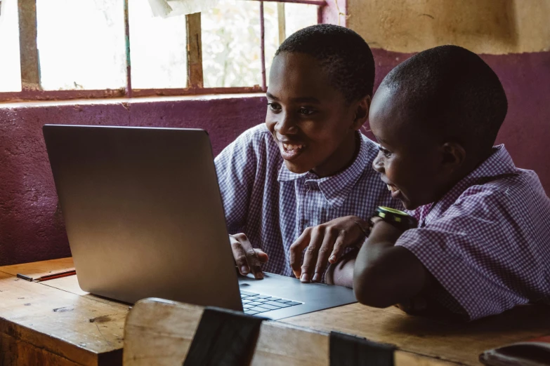 young children sitting in front of their laptop on the table