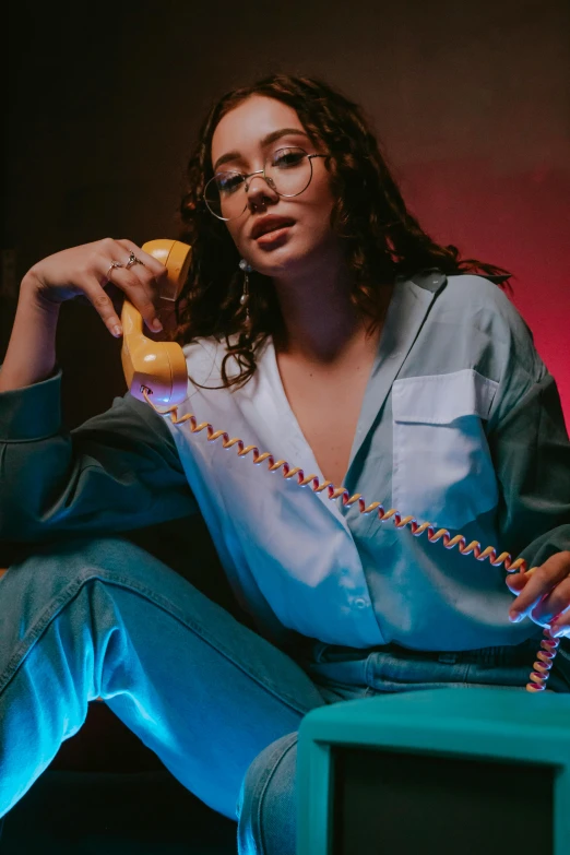 a woman sits in a chair while talking on the telephone