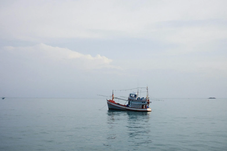 a small fishing boat anchored at a harbor