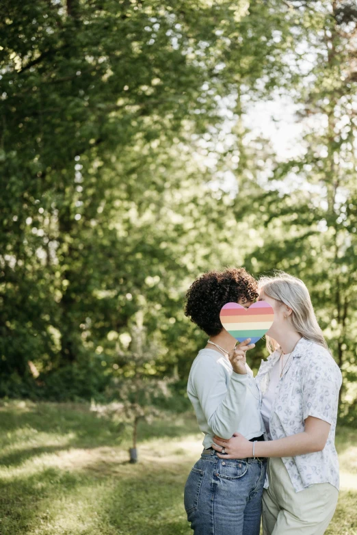 two women share a kiss while standing outside