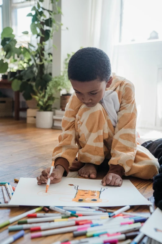 a  is sitting on the floor drawing