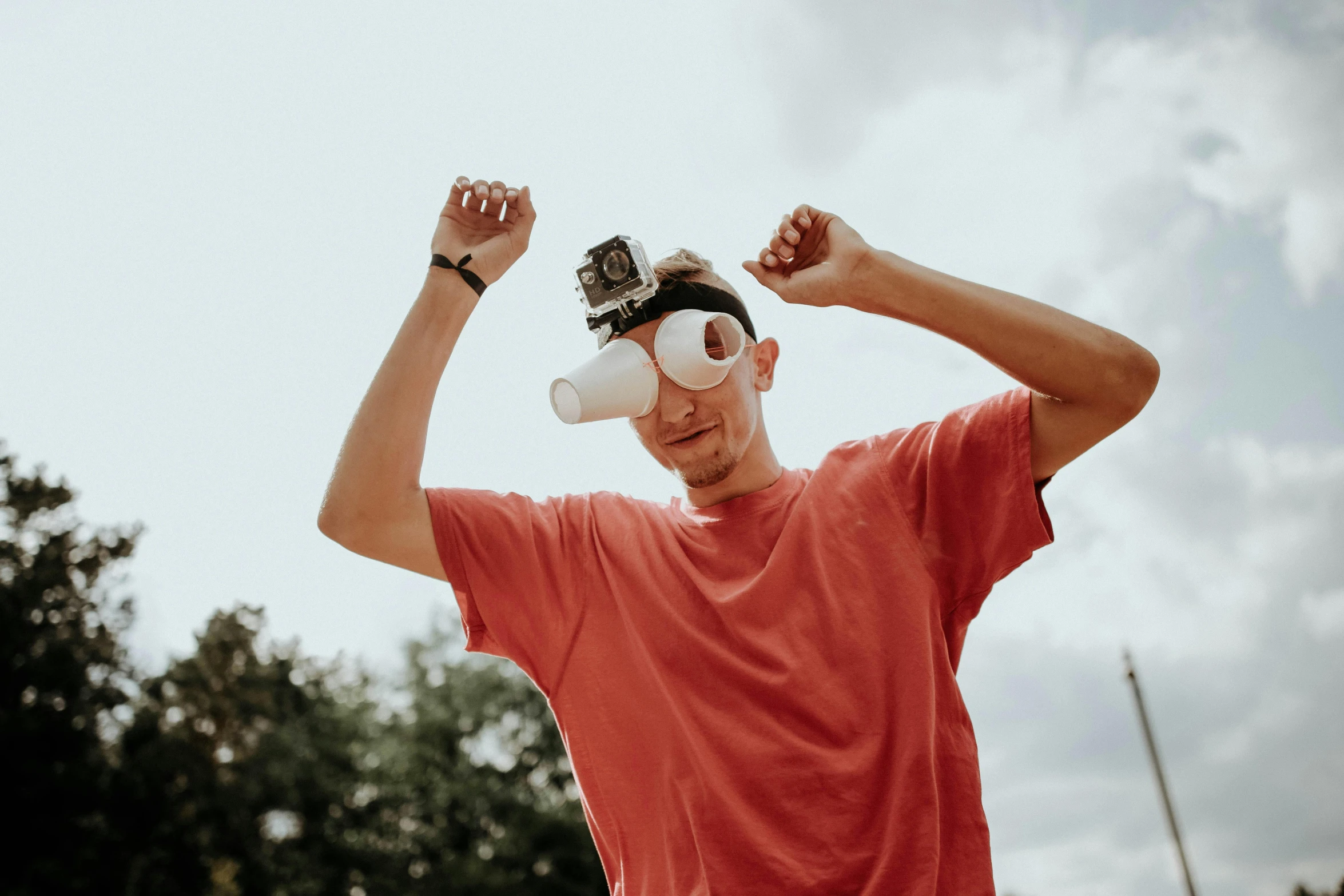 man wearing a cap and glasses holding up his arms