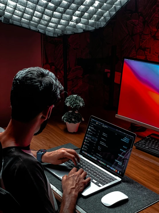 a man sitting in front of his laptop computer