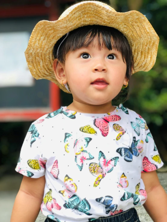  wearing hat with erfly print at outdoor area