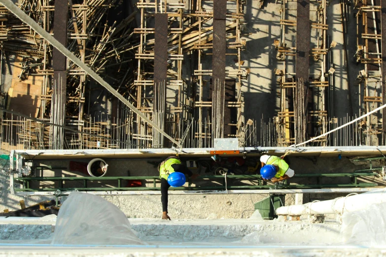 workers are working with tools while they work on the side of a building