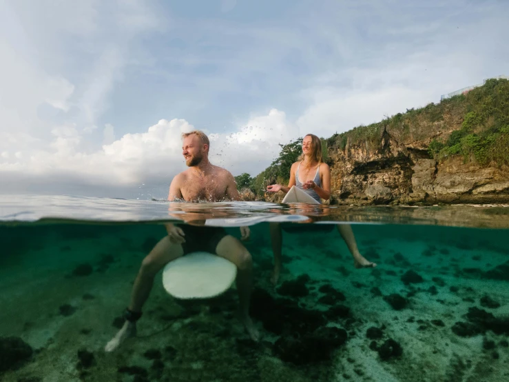 a man and a woman who are riding surfboards