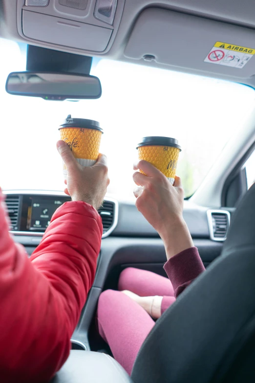 two people holding coffee cups in their hands