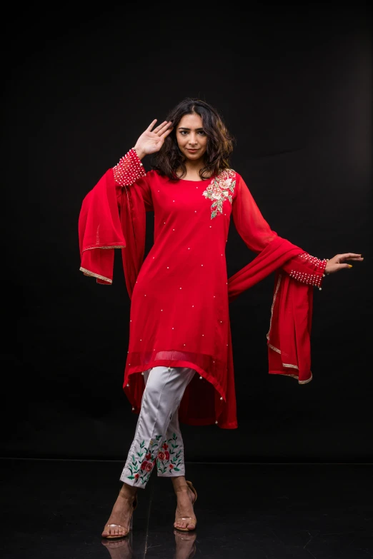 a beautiful woman standing up against a black backdrop