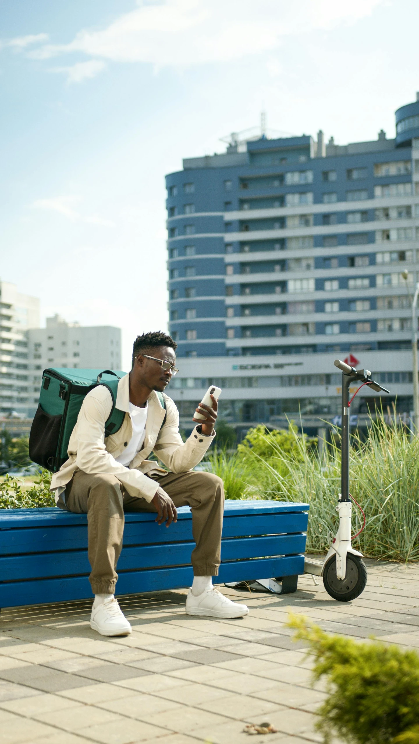 a man sitting on a bench while using his cell phone