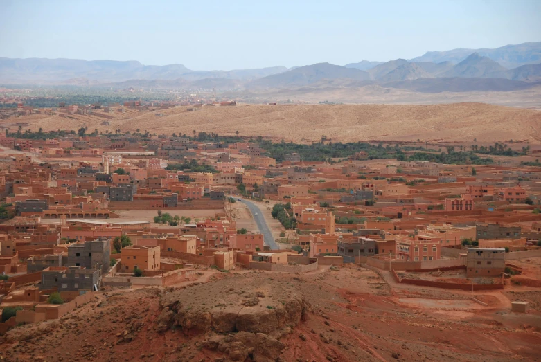 a town surrounded by hills with a road running through them
