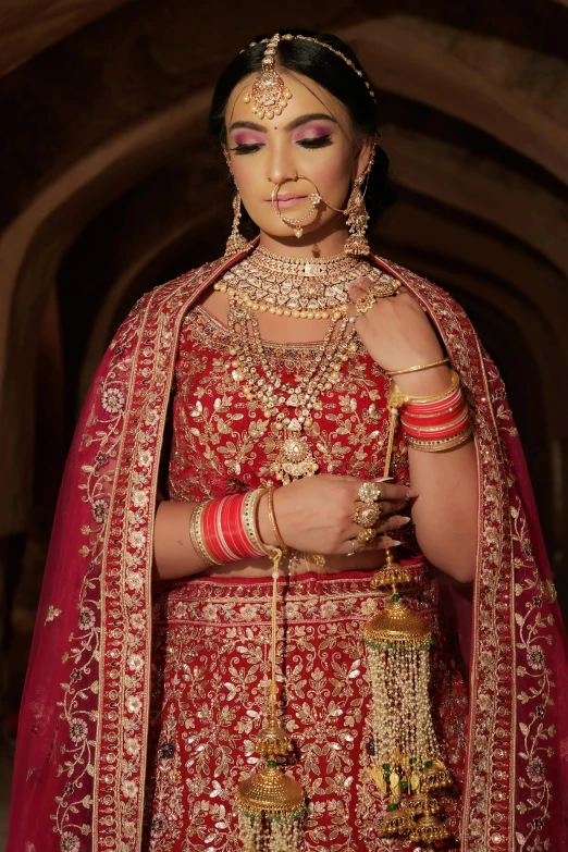 a woman wearing a red dress and gold jewelry