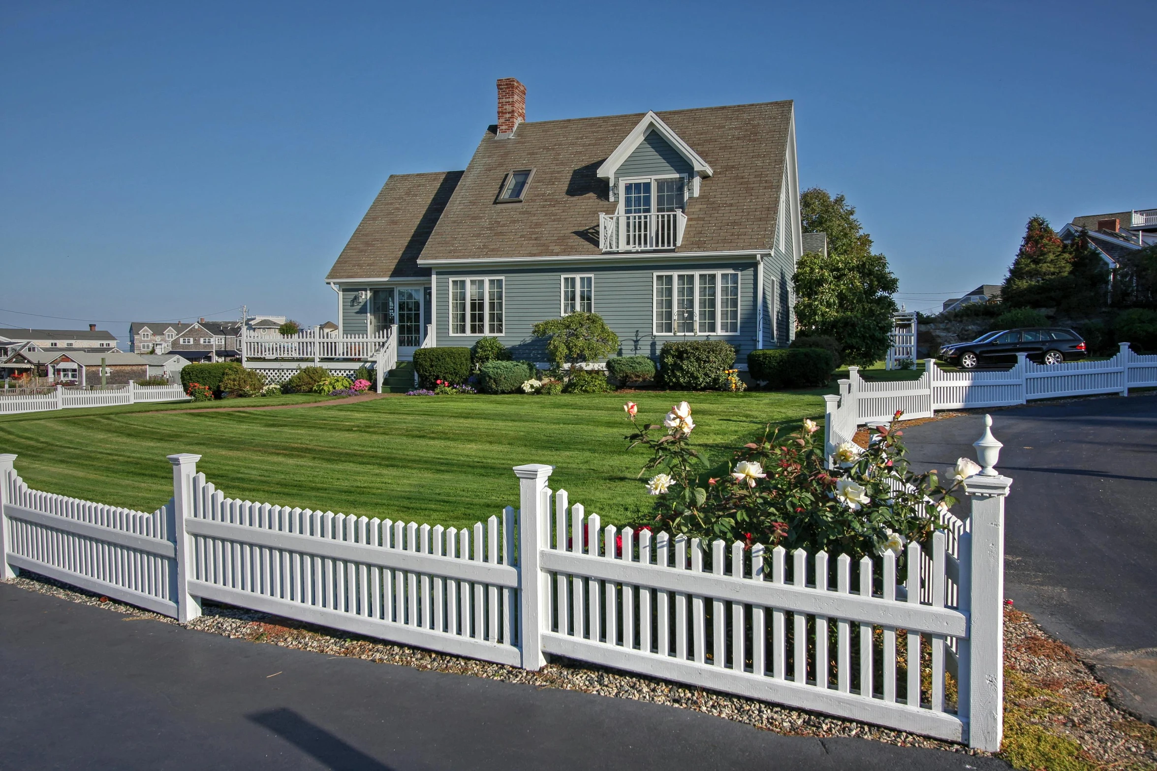 a white picket fence in front of a large house