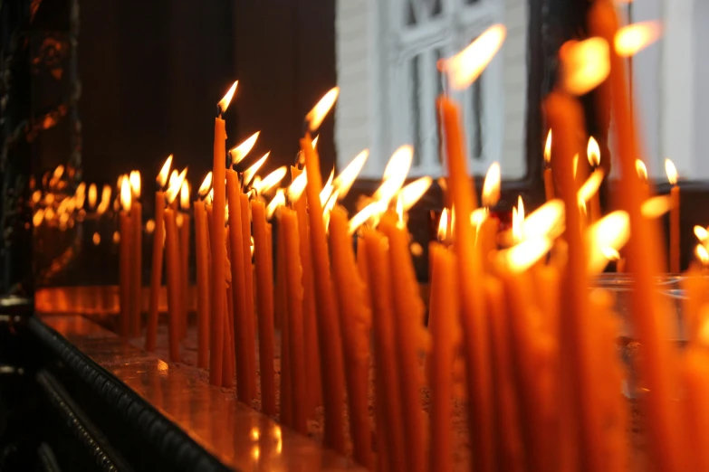 a lot of orange candles are lined up