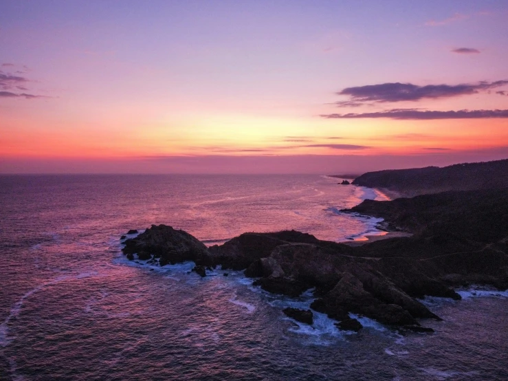 a lighthouse with the sun going down over the ocean