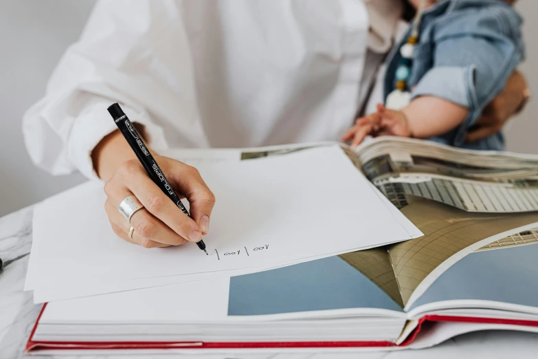 a person is doing paperwork while holding a pen